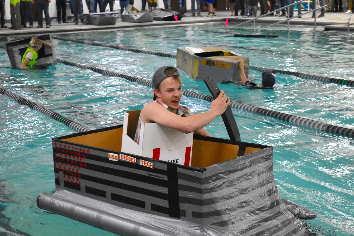 Students in a cardboard boat regata.